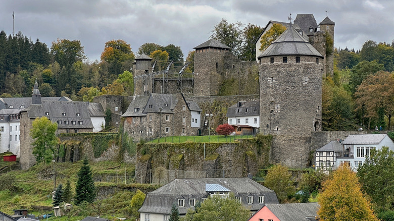 Hilltop fortress surrounded by lush vegetation in Monschau, Germany