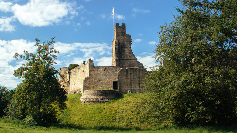 Prudhoe Castle sits on top of a grassy hill.
