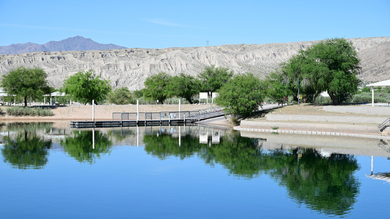 A boat ramp at Big Bend at the Colorado with trees, mountains, and picnic shelters in the background