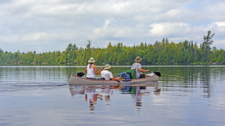 Three people canoeing on Poplar Lake in Minnesota