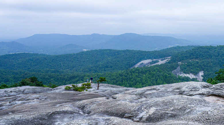 A family in the distance on a bluff overlooking the Blue Ridge Mountains near Sparta, North Carolina