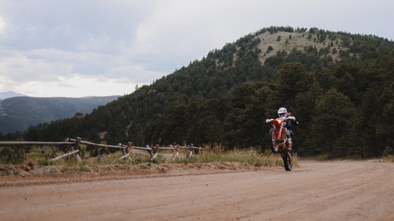 Dirt bike doing a wheelie down a dirt road on Sugarloaf Mountain