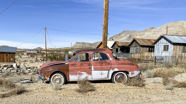 Rusted car and old mining homes in Darwin, CA