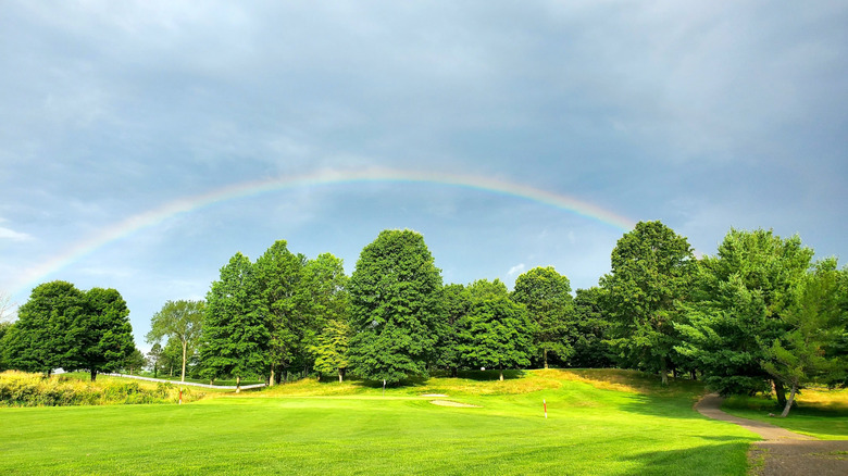 Rainbow over the fairway at Kyber Run Golf Course in Johnstown, Ohio, with lush greens and trees beneath a clearing sky