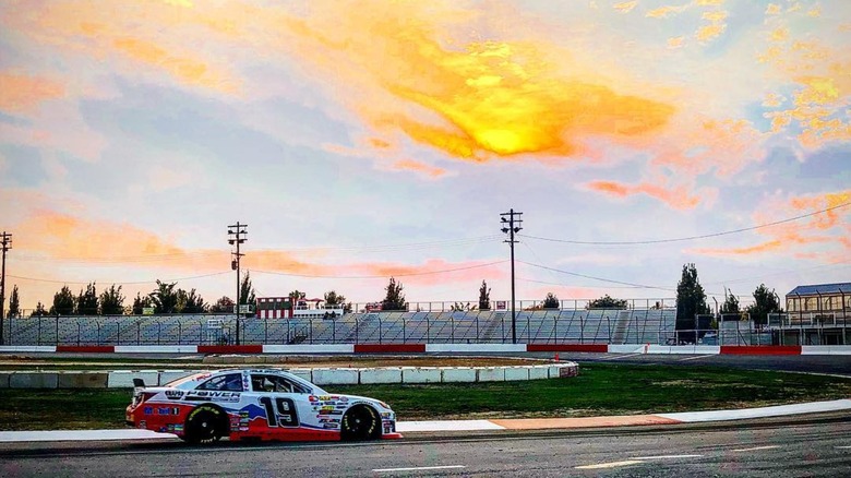 Nascar car speeding on Meridian Speedway at sunset