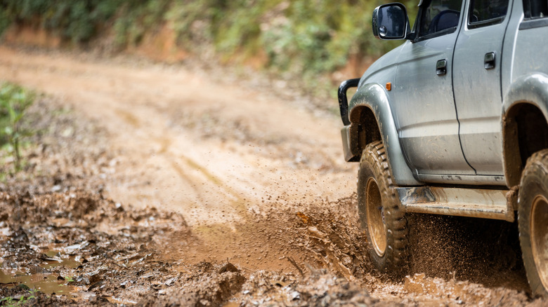 off-roading car driving through the mud