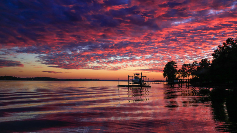 Boat on a small dock on Lake Murray in Irmo, South Carolina during sunset with clouds billowing in the sky.