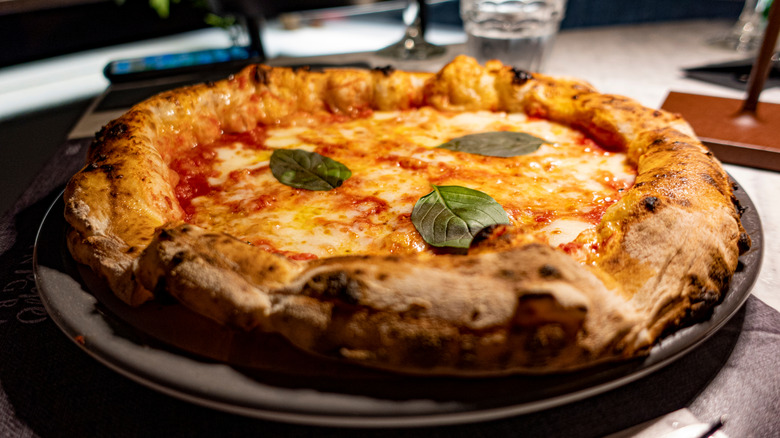 A Neapolitan-style pizza with mozzarella and basil.