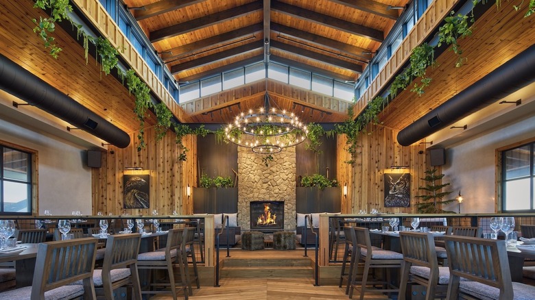 The interior of Haven Restaurant with high ceilings and a candle-lit chandelier over the fireplace