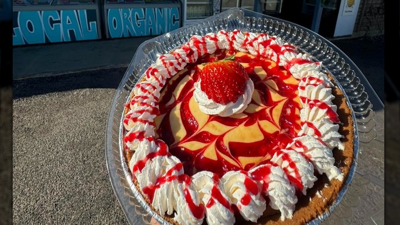 Strawberry pie with whipped cream in plastic tin