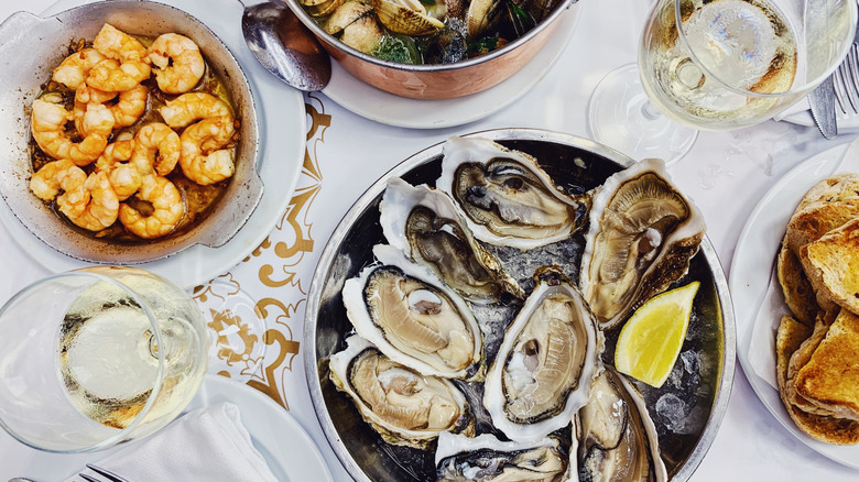 Plates of seafood and wine glasses on table
