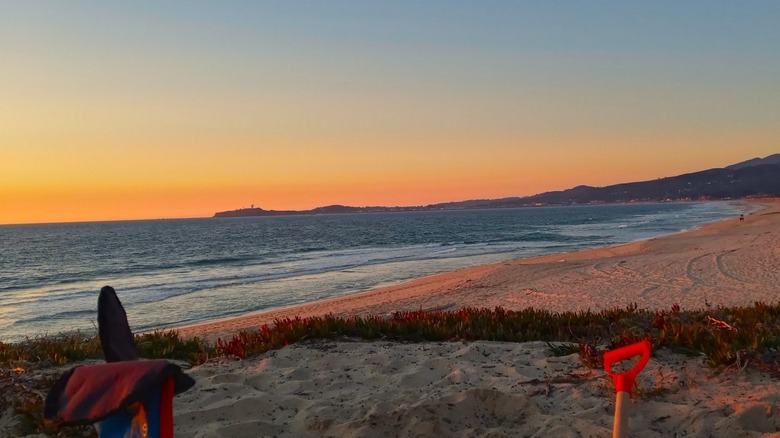 A sandy bluff at Francis Beach Campground site 16 overlooks the beach at sunset.