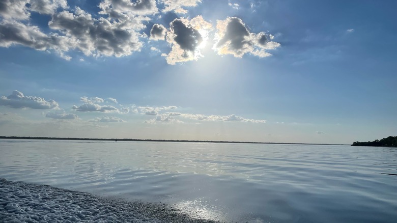 Sun rays piercing through the clouds and onto Cheney Reservoir at Cheney State Park, Kansas