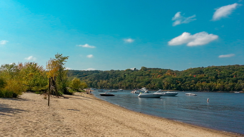 Boats anchored near sandy beach on lake