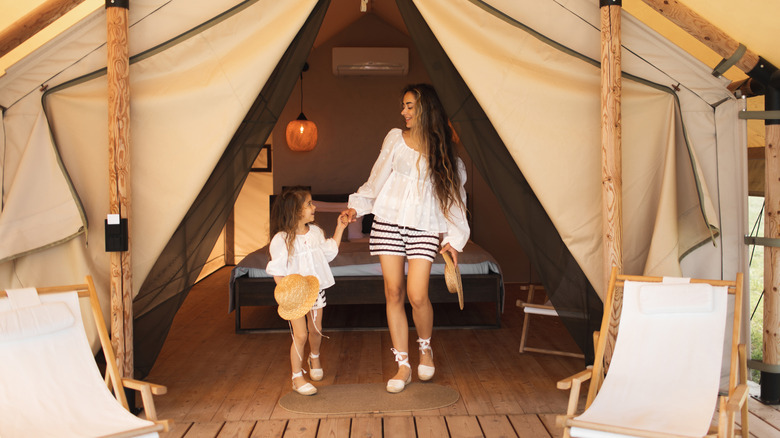 Mother and child standing inside glamping tent