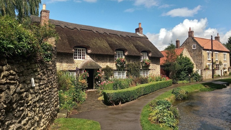 The lovely thatched-roofed Beck Cottage sits by a stream