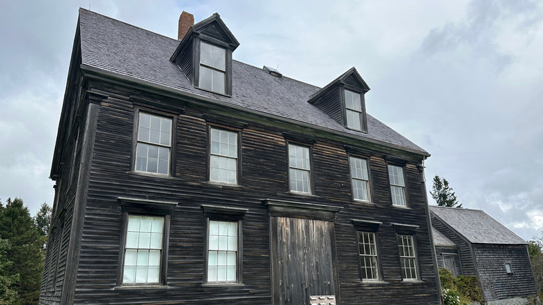The Olson House in Cushing, Maine, a historic dark wooden farmhouse with multiple windows