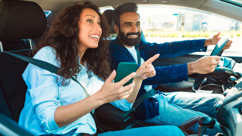 Passenger in car helping driver with directions