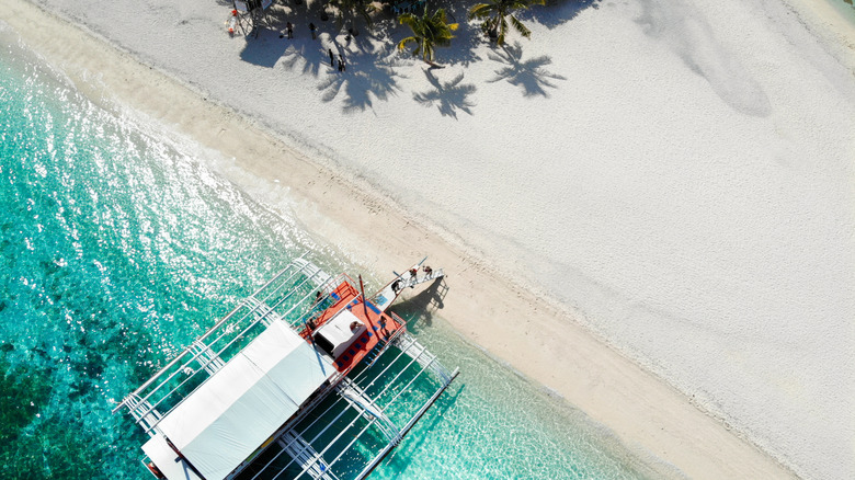 Bird's eye view of pontoon boat next to white sand beach in Kalanggaman Island, Philippines