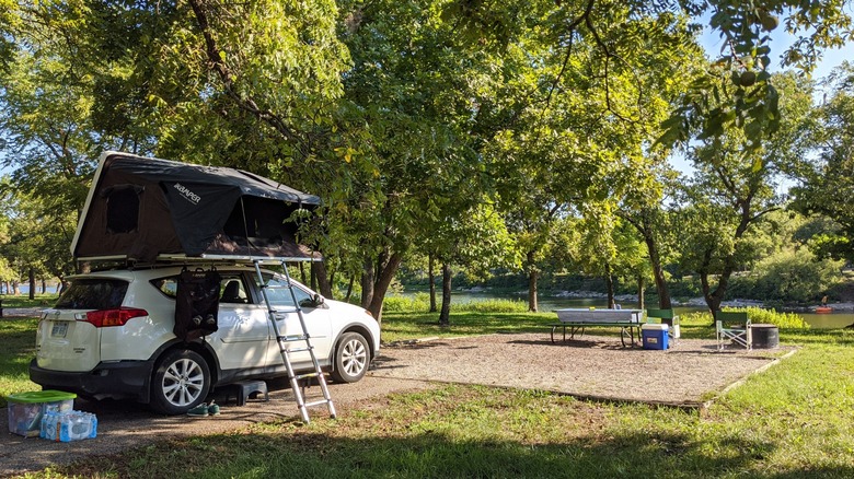 A car-top tent setup with a picnic table in the distance at the Crawford State Park campground
