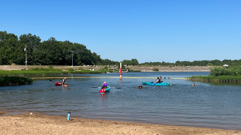 A group of people launching their kayak into lake at Crawford State Park, Kansas