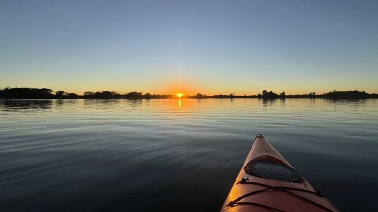 A view from a kayak on El Dorado Lake, Kansas, as the sun dips below the horizon