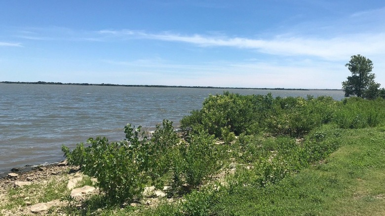 El Dorado Lake in Butler County, Kansas, surrounded by green grass and brush at midday