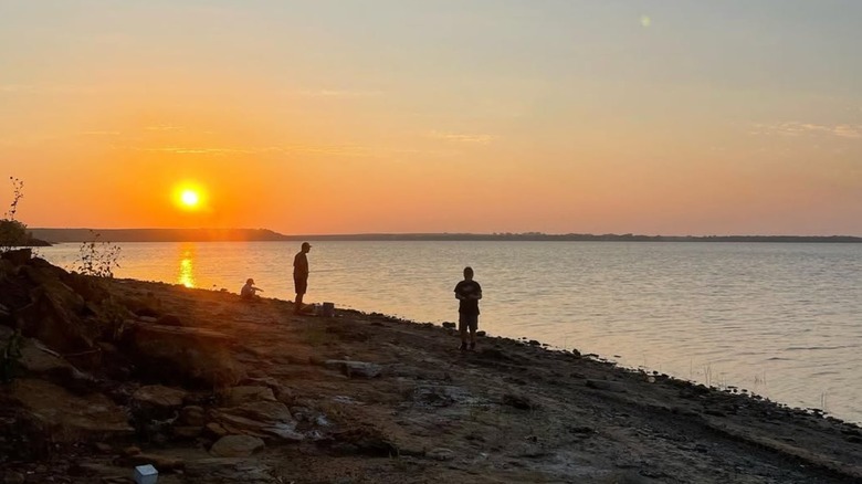 People on the shore of Kanopolis Lake at sunset.