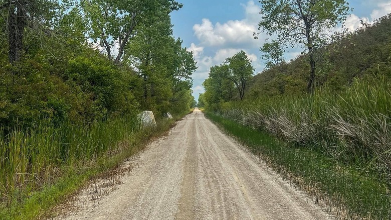 The Flint Hills Trail running in between grassy hills.