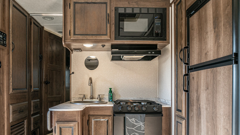A kitchen in an RV with a microwave and appliances