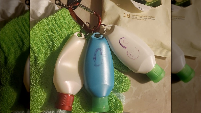 Travel-sized shampoo bottles hanging off a lanyard for camping.