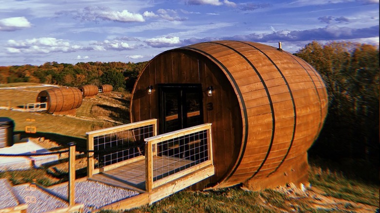 A barrel shaped house overlooking the woods in autumn at Bourbon Barrel Retreats, in Kentucky.