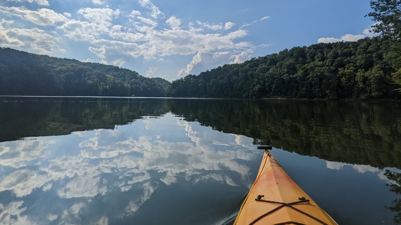 A kayak floating on the calm waters of Yatesville Lake at Yatesville Lake State Park, Kentucky, with the scenery mirrored on the water