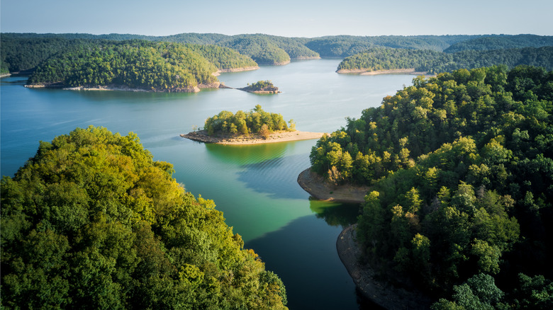 Aerial view of Cumberland Lake in Kentucky, with treed hills and a blue sky in the background