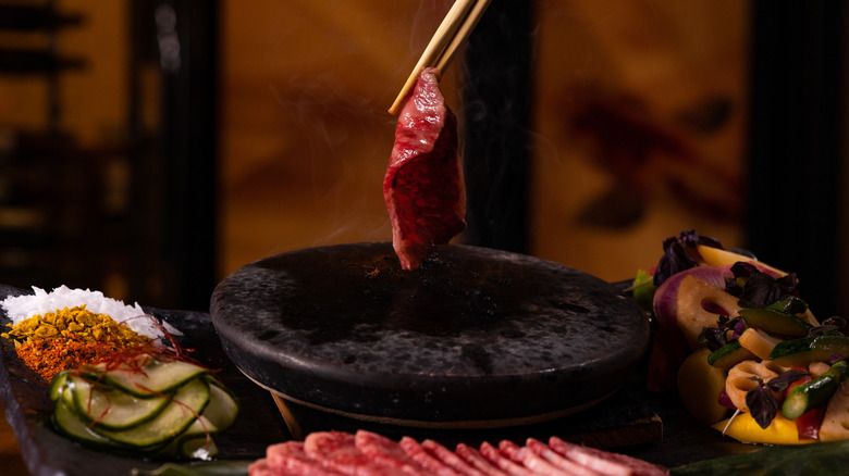 Japanese Wagu being cooked on a hot stone at a dining table at Kuro restaurant in the Hard Rock Hotel & Casino Atlantic City
