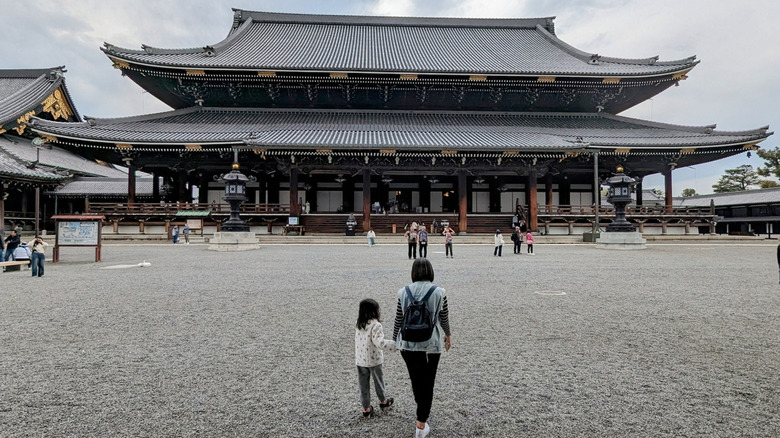 A parent and child approaching Higashi Hongan-ji temple in Kyoto, Japan