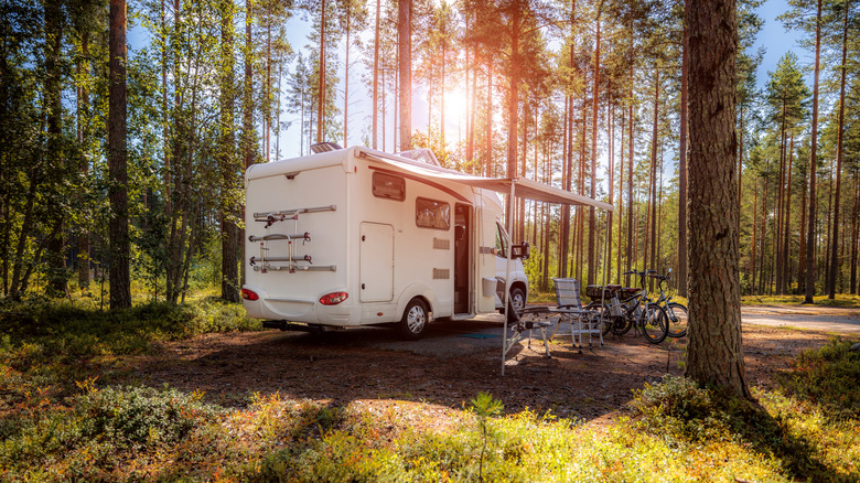 an RV camped in a wooded setting