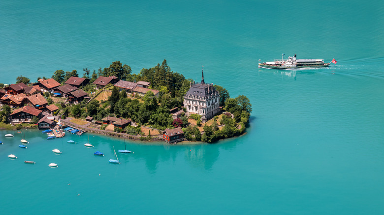 An aerial view of Iseltwald, surrounded by Lake Brienz, with a steam-paddler cruise in the background