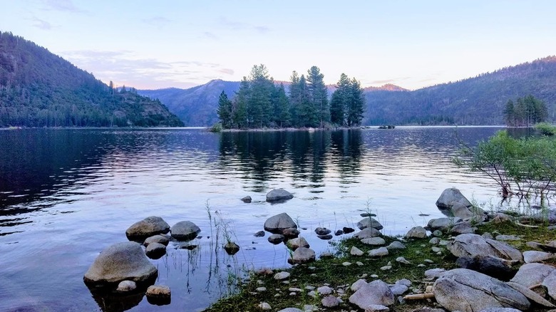 Mountains and trees reflect in rippling Lake Eleanor, Yosemite