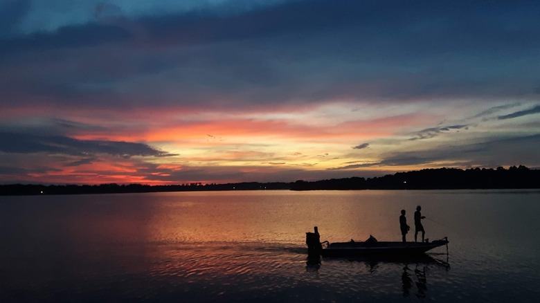 Two people on fishing boat on Lake Holbrook at sunset