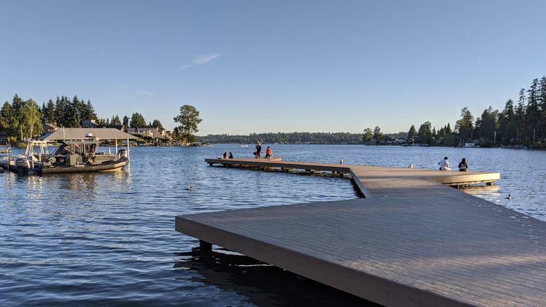 The winding fishing pier and a boat on Lake Stevens lined with trees in Lake Stevens, Washington