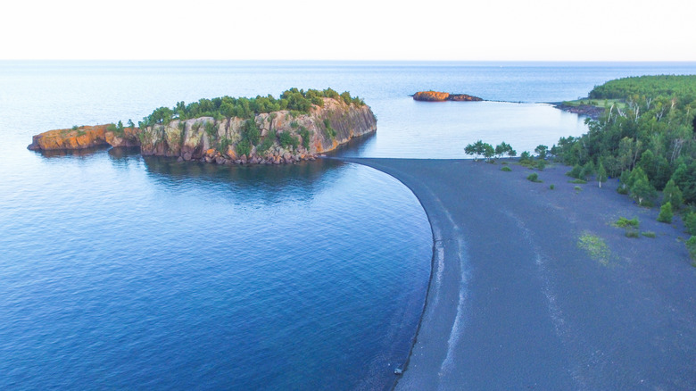 An aerial photo of Black Beach as it comes to a point and touches Turtle Island