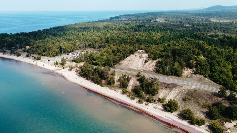 An aerial photo of Great Sand Bay showing the long strip of sand, the road above, and Keweenaw Peninsula continuing into the distance