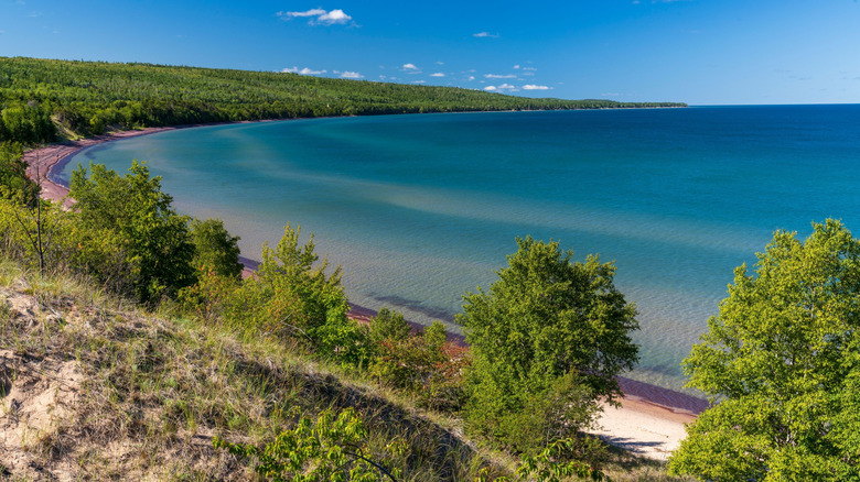 A wide shot of Great Sand Bay, Michigan, from the hill above the beach, with beautiful blue water