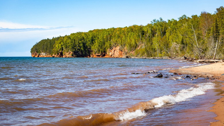 Close to the waterline of Meyers Beach with the forest on one side, the cliffs of the lakeshore, and the horizon to the left