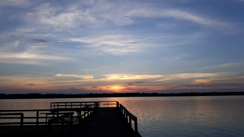 The sun low on the horizon over Lake Washington in Mississippi