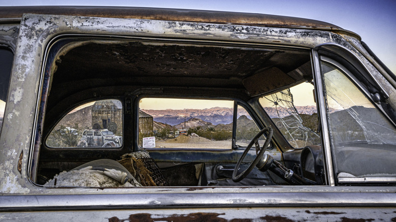 The Nevada desert through a rusted, abandoned car window