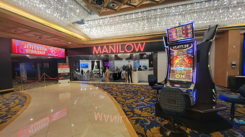 lawn and palm trees un front of a tall, curved white building, blue sky