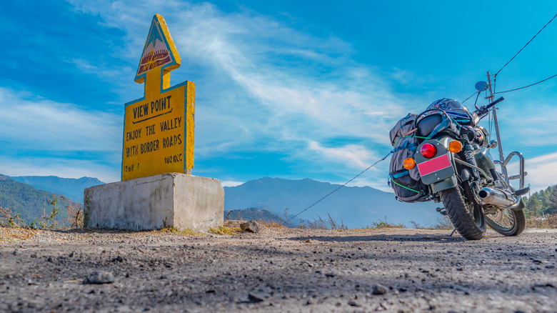 Parked bike with a backpack on a road trip in Bhutan.