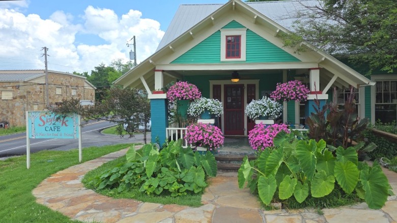 Exterior shot of Skylark Cafe, with flowers, and the Ozark Heritage Arts Center in the background.